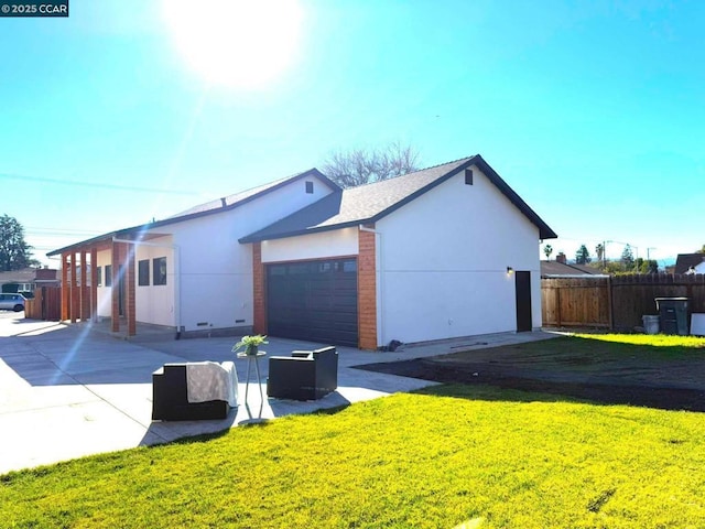 view of property exterior featuring a garage and a lawn