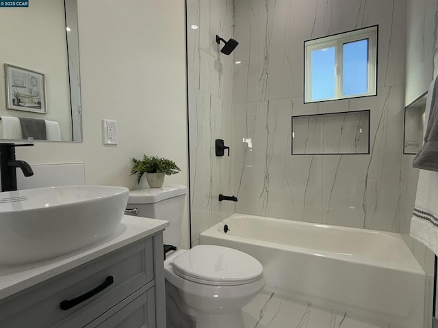 full bathroom featuring tiled shower / bath combo, vanity, and toilet