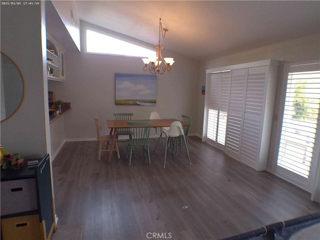 dining area with dark wood-type flooring, lofted ceiling, and a chandelier