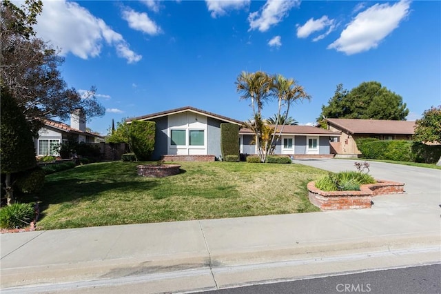 view of front of house with concrete driveway and a front lawn