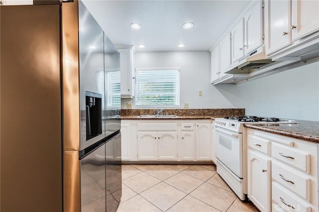 kitchen with light tile patterned flooring, a sink, white cabinets, stainless steel fridge with ice dispenser, and gas range gas stove