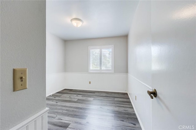 empty room featuring wainscoting and wood finished floors