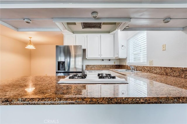 kitchen featuring pendant lighting, white cabinets, a sink, and stainless steel refrigerator with ice dispenser