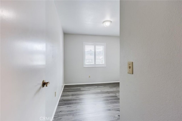 unfurnished room featuring baseboards and wood finished floors