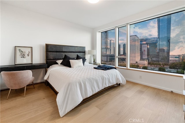 bedroom with multiple windows and light hardwood / wood-style flooring