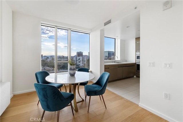 dining space featuring sink and light hardwood / wood-style floors