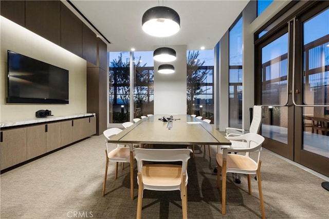 dining area with light carpet and french doors