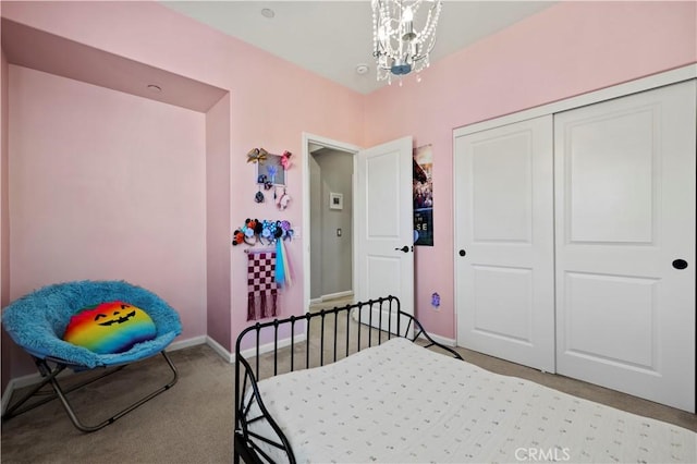 carpeted bedroom featuring a notable chandelier and a closet