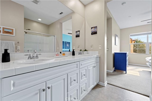 bathroom featuring vanity and a shower with door