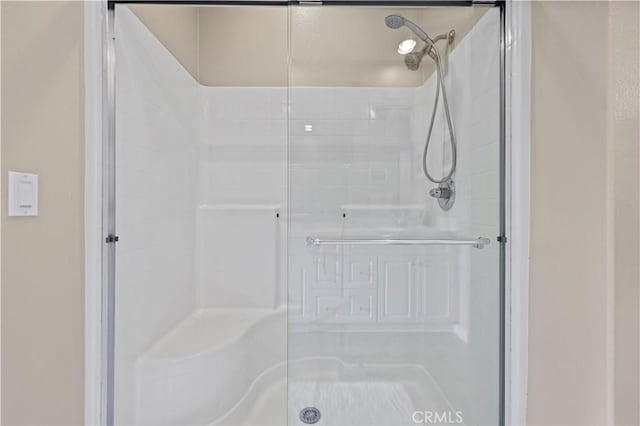 bathroom featuring a shower with door