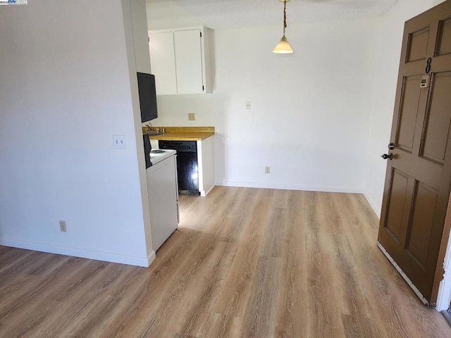 kitchen featuring hanging light fixtures, white cabinets, and light hardwood / wood-style flooring