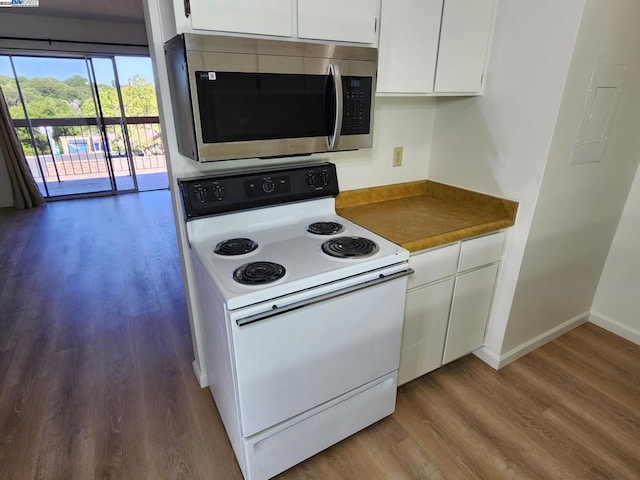 kitchen with white range with electric stovetop, white cabinets, and dark hardwood / wood-style floors