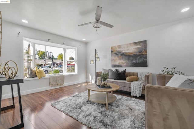 living room with dark wood-type flooring and ceiling fan