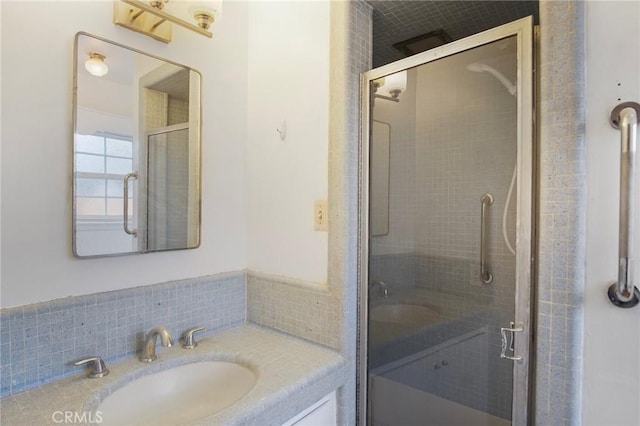 bathroom with a shower with shower door and vanity