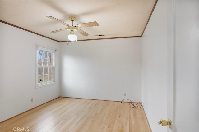 empty room featuring crown molding, light hardwood / wood-style flooring, and ceiling fan