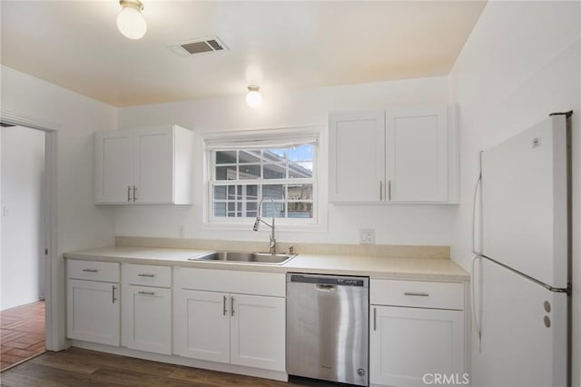 kitchen with sink, white cabinetry, white fridge, and stainless steel dishwasher