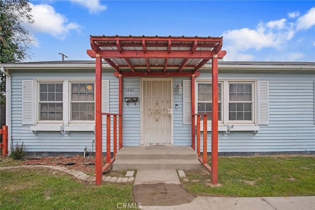 view of exterior entry with a yard