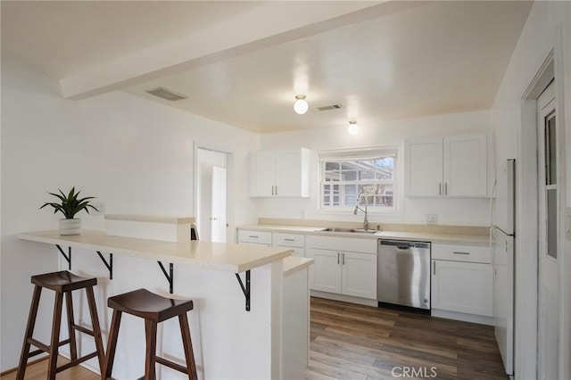 kitchen featuring dishwasher, sink, white cabinets, dark wood-type flooring, and a breakfast bar