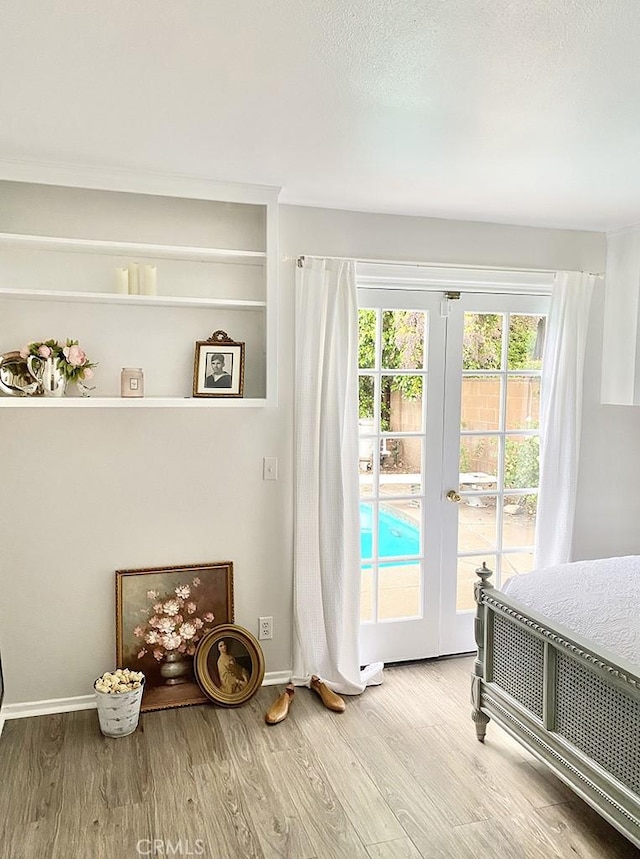 bedroom featuring access to exterior, wood-type flooring, and french doors