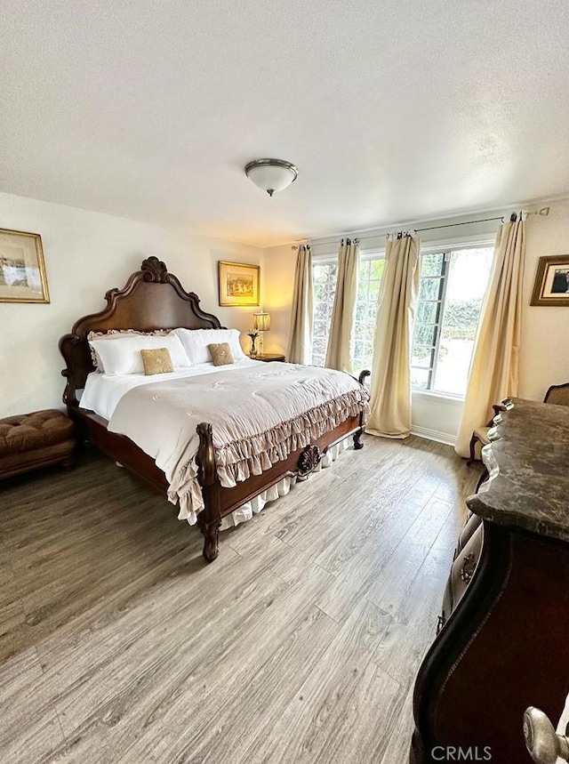 bedroom with light hardwood / wood-style flooring and a textured ceiling