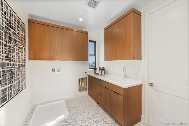 laundry area featuring cabinets, washer hookup, and sink