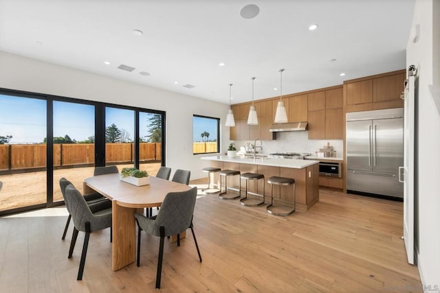 dining room with sink and light hardwood / wood-style flooring