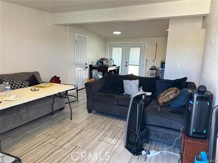 living room with beam ceiling and french doors