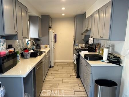 kitchen featuring sink, gray cabinets, and black appliances