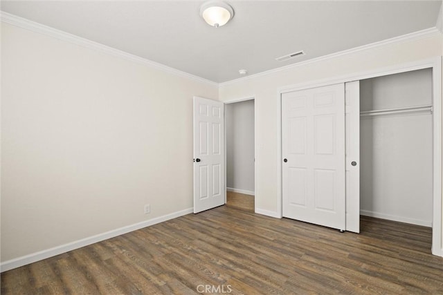 unfurnished bedroom with a closet, crown molding, and dark hardwood / wood-style flooring