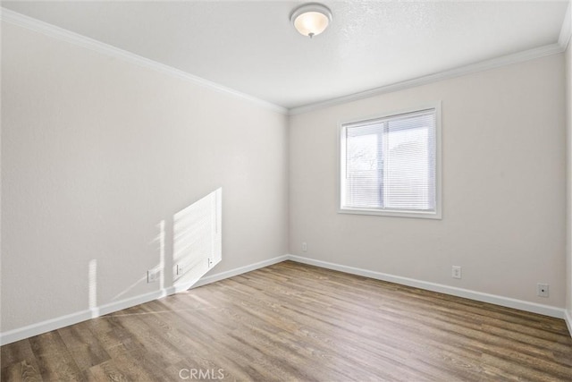 empty room featuring hardwood / wood-style flooring and ornamental molding