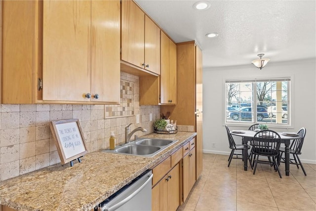 kitchen with light brown cabinetry, tasteful backsplash, dishwasher, sink, and light tile patterned flooring