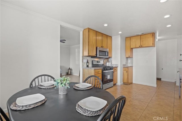 dining room with ornamental molding and light tile patterned floors