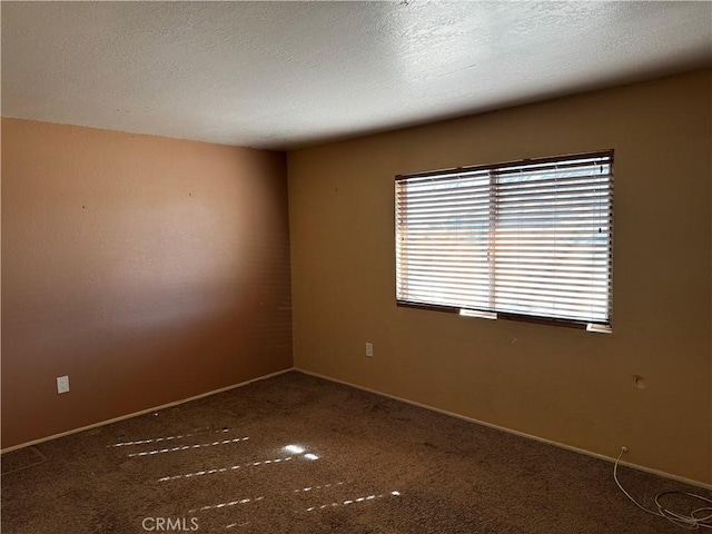 spare room featuring dark carpet