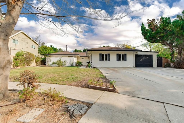 ranch-style house featuring a garage and a front lawn