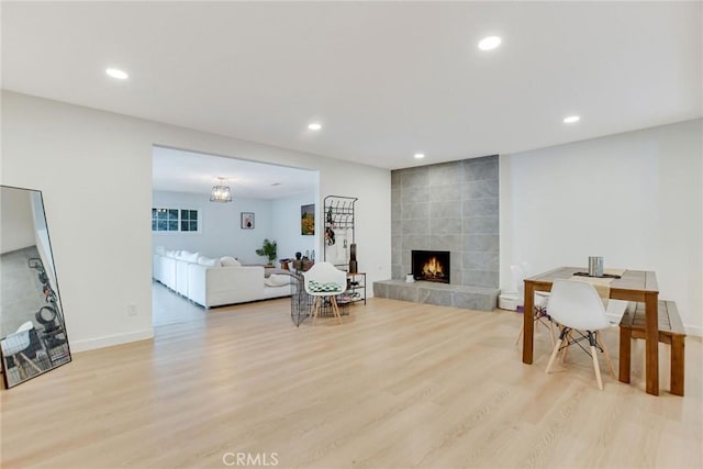 living room with a tiled fireplace and light hardwood / wood-style flooring