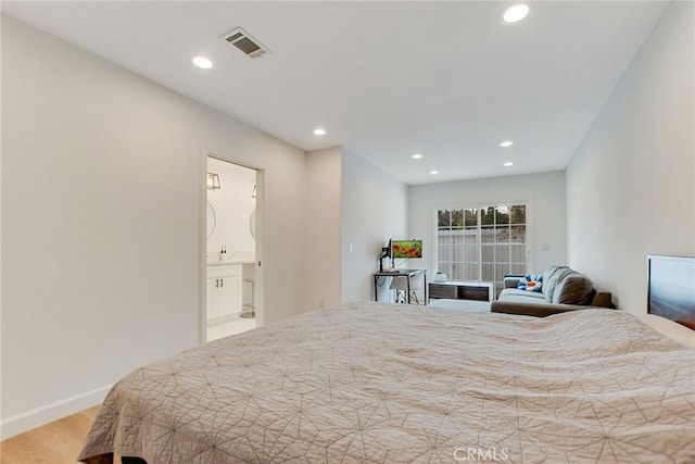 bedroom with light hardwood / wood-style floors and ensuite bathroom