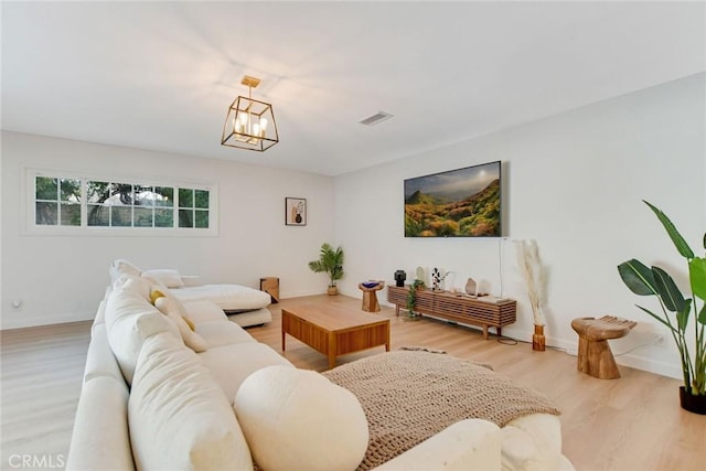 living room with a notable chandelier and light hardwood / wood-style floors