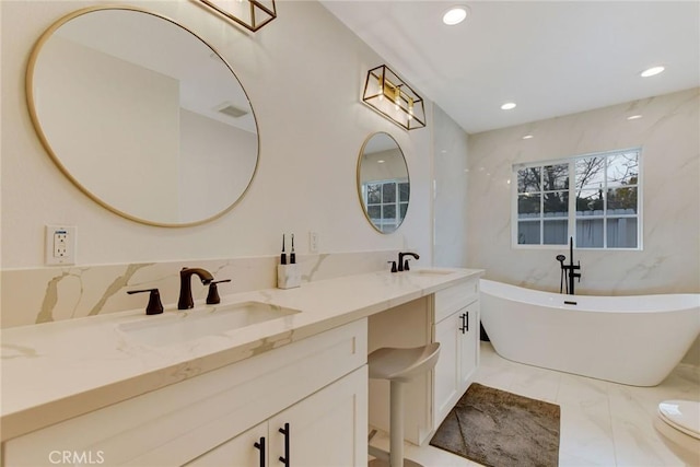 bathroom featuring toilet, vanity, and a bathtub