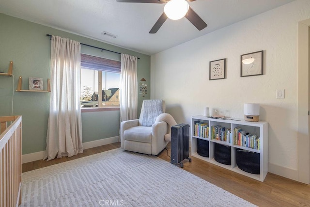 sitting room featuring light wood-type flooring and ceiling fan