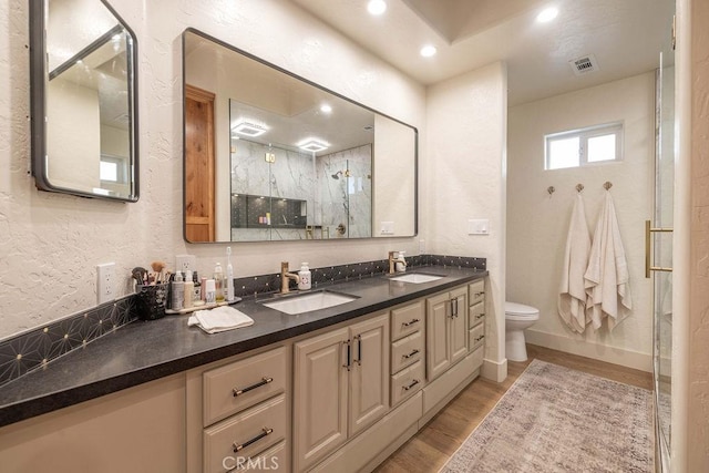 bathroom featuring hardwood / wood-style flooring, toilet, an enclosed shower, and vanity