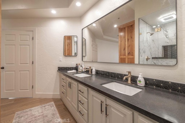 bathroom featuring hardwood / wood-style flooring, a tray ceiling, and vanity