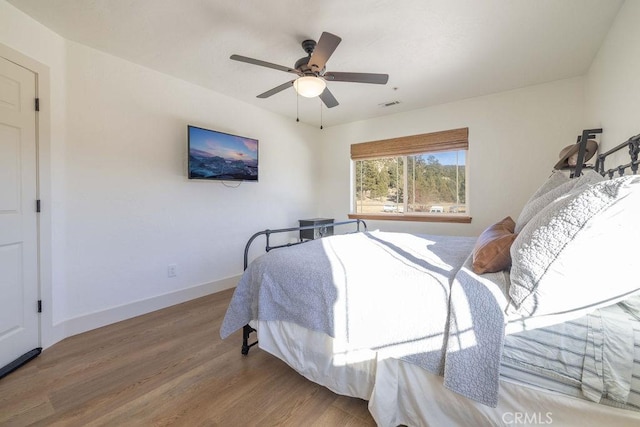 bedroom with ceiling fan and hardwood / wood-style flooring