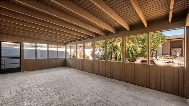 unfurnished sunroom featuring wooden ceiling and beamed ceiling