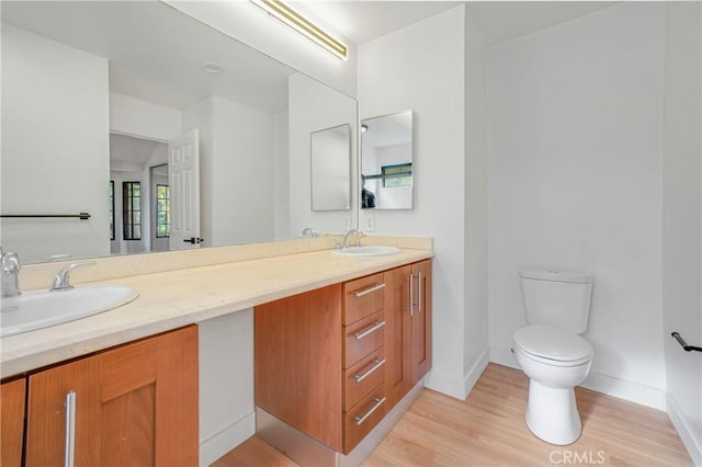 bathroom featuring wood-type flooring, toilet, and vanity