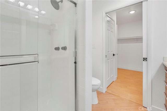 bathroom with wood-type flooring, an enclosed shower, vanity, and toilet