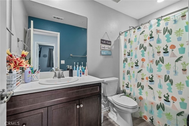 full bathroom with hardwood / wood-style floors, toilet, vanity, and shower / tub combo with curtain