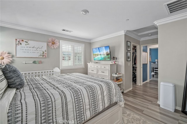 bedroom featuring crown molding and light hardwood / wood-style floors