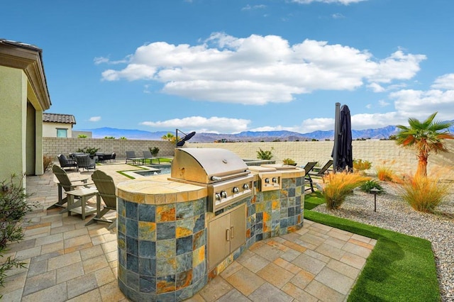 view of patio featuring area for grilling, a mountain view, and a grill