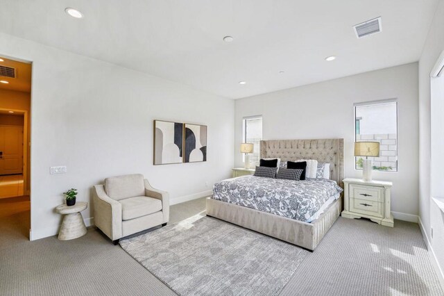 bedroom with multiple windows and light carpet