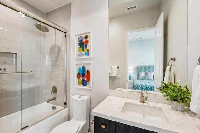 full bathroom with enclosed tub / shower combo, vanity, and toilet